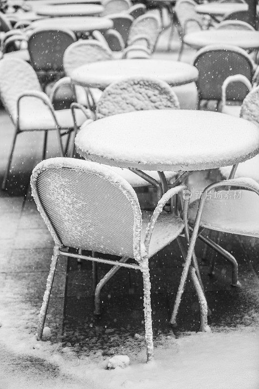 一场暴风雪过后，咖啡馆的桌子被雪覆盖了