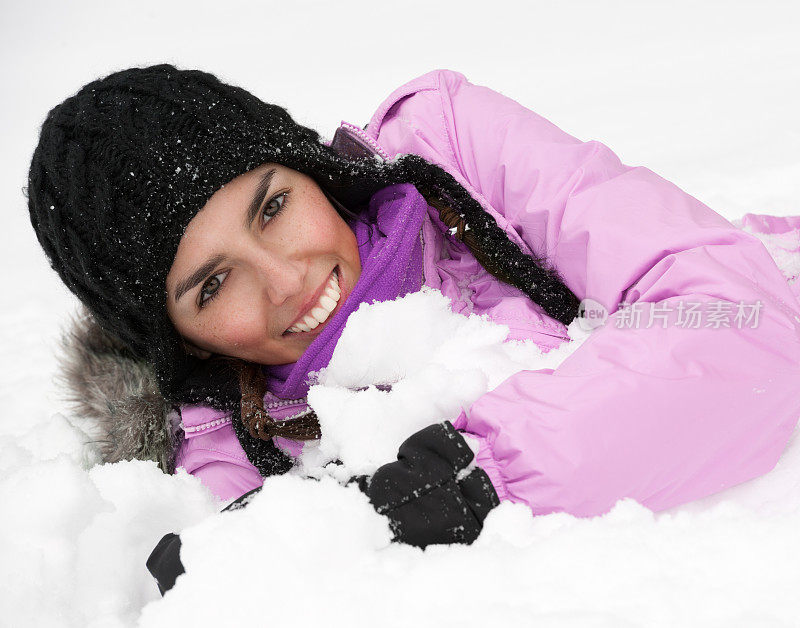 美丽的自然女子躺在雪中