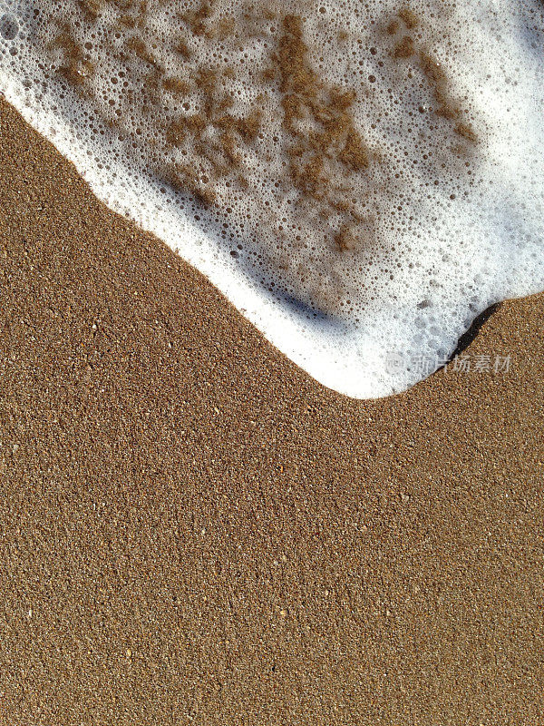 海浪拍打着沙滩上的沙子