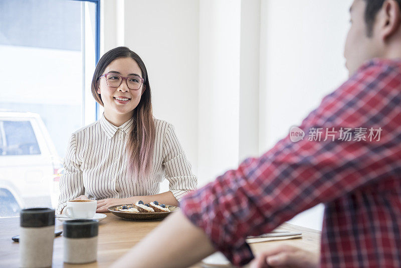 迷人的年轻中国亚洲女商人在咖啡馆与朋友