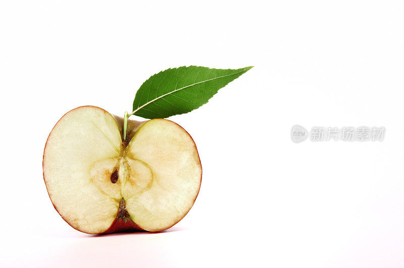 带绿叶的苹果，切成两半，孤立在白色上