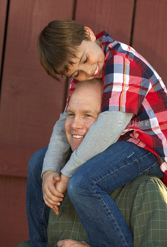 快乐的父亲和儿子在他的肩膀上