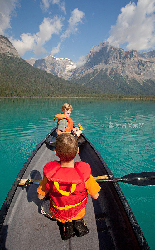 两个年轻的白人男孩划着独木舟在加拿大落基山脉