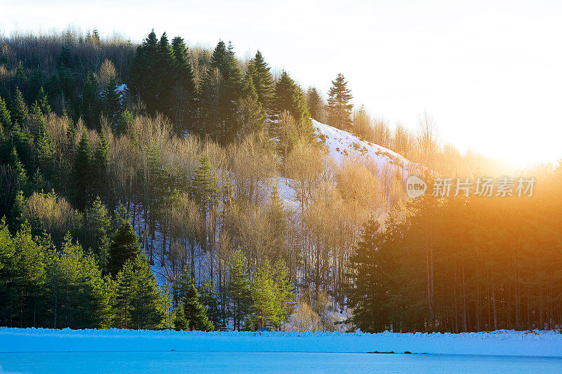 日落时的森林和冰湖