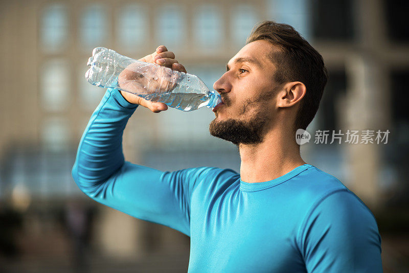 运动员喝着瓶子里的新鲜水。