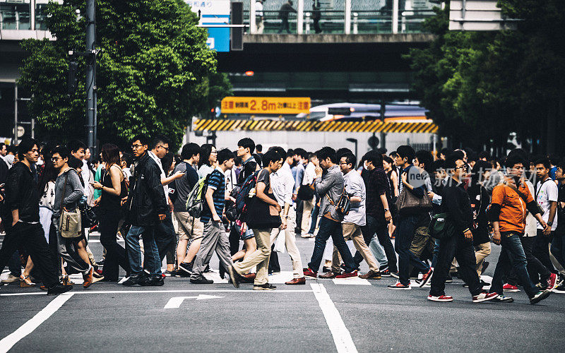 在东京秋叶原，人们正在穿过街道。