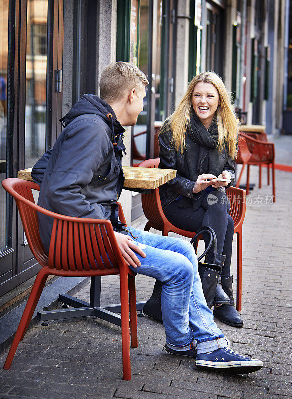 年轻夫妇在街头咖啡馆玩得很开心
