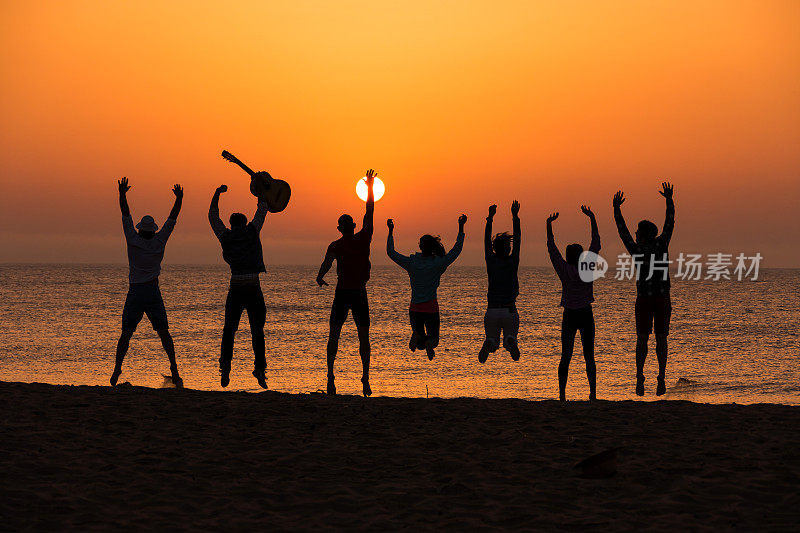 日落时分，朋友们在海滩上跳跃
