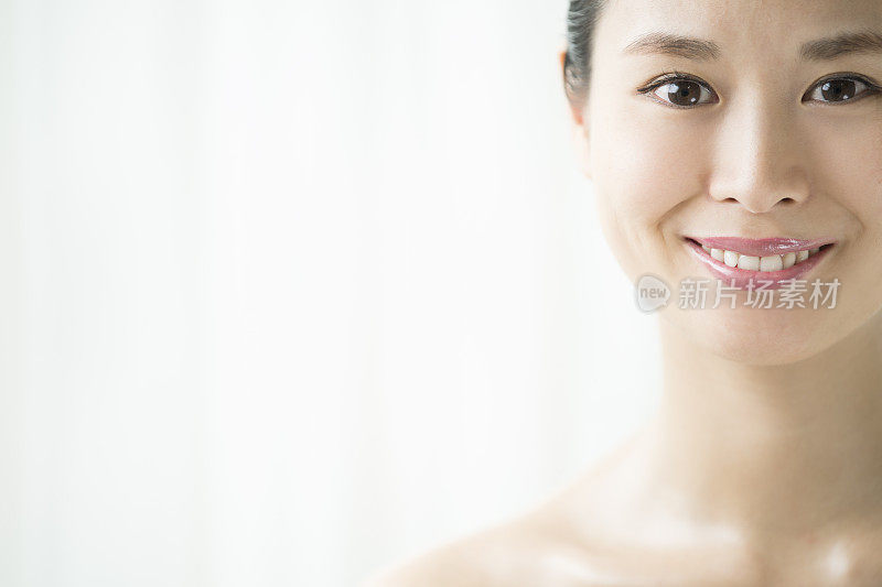 一个带着相机微笑的女人在一个干净的环境中。