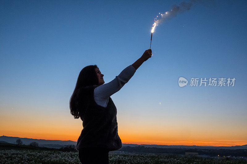 年轻的女孩在户外拿着烟花