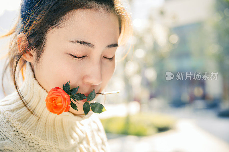 亚洲女孩在太阳耀斑下的红花，上海，中国