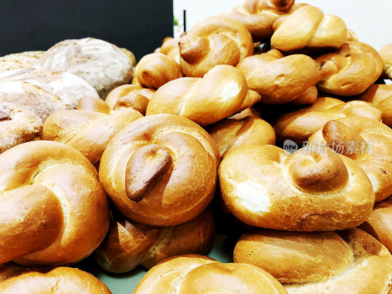 桌子上有很多新鲜的面包和小圆面包。面包的业务。面包房里的新鲜谷物和种子做成的面包。