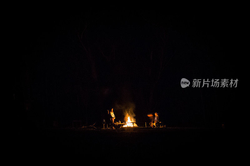 在一个没有月亮的夜晚，一群爱冒险的年轻露营者围着篝火站着