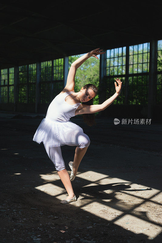 白色的芭蕾舞女演员在废弃的建筑里跳舞