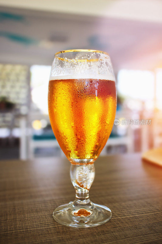酒吧桌上放着一杯精酿啤酒，背景是精致的散焦