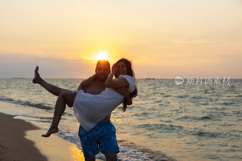 日落时分沙滩上的浪漫情侣