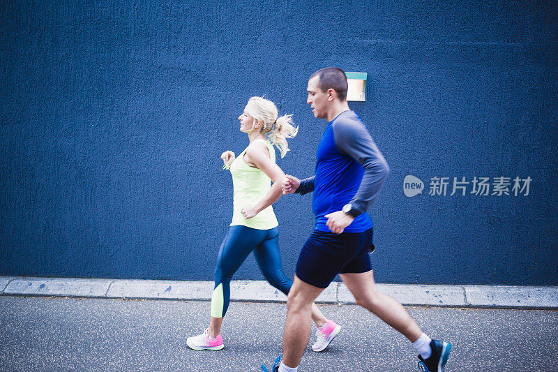 一对运动员夫妇在城市的街道上晨跑