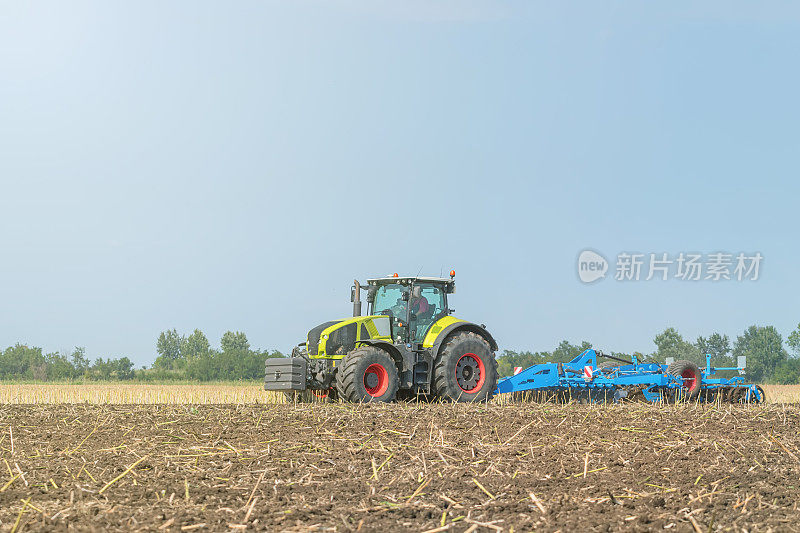 农民在拖拉机上准备土地、苗床、中耕机。农业拖拉机景观。