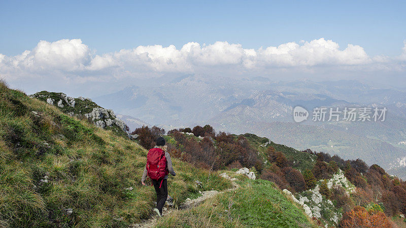 徒步旅行的妇女走在高山路上