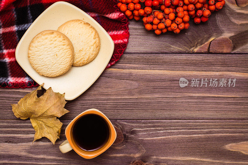 秋天的静物——咖啡、饼干、格子呢、笔记本和木制背景上的铅笔