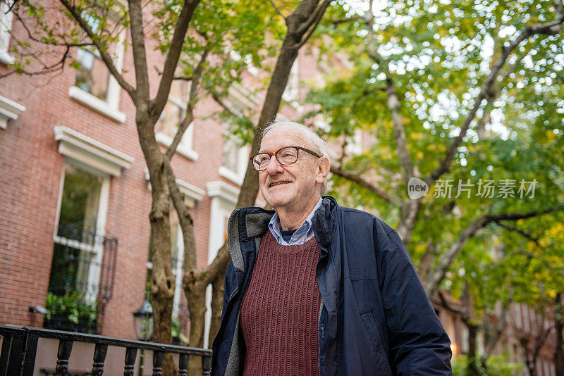 在纽约曼哈顿切尔西社区散步的微笑老人