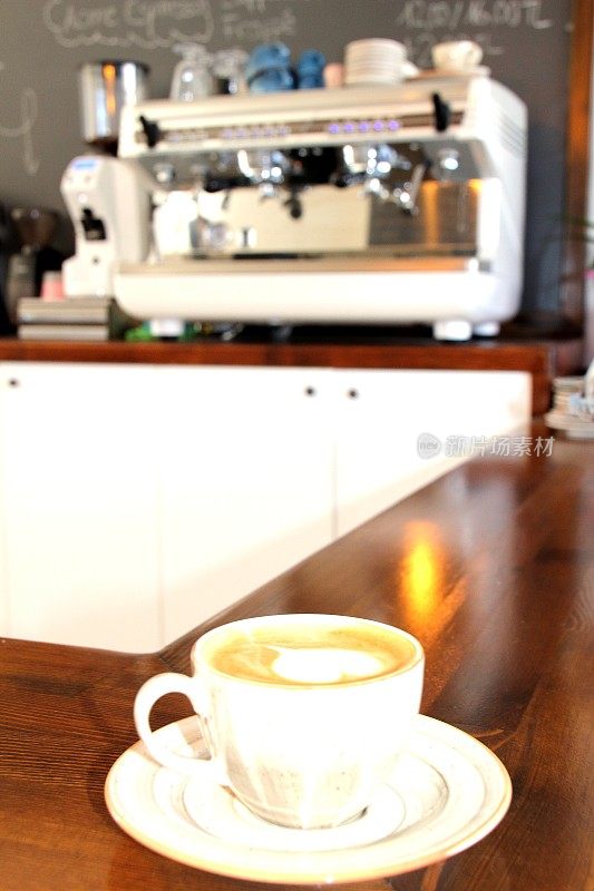心形咖啡杯和现代咖啡机的背景