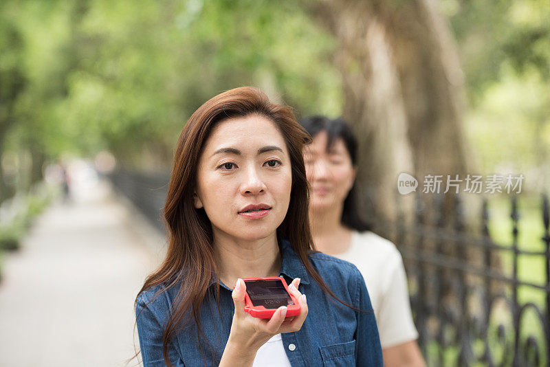 一名拿着手机的女子走在台北大街上