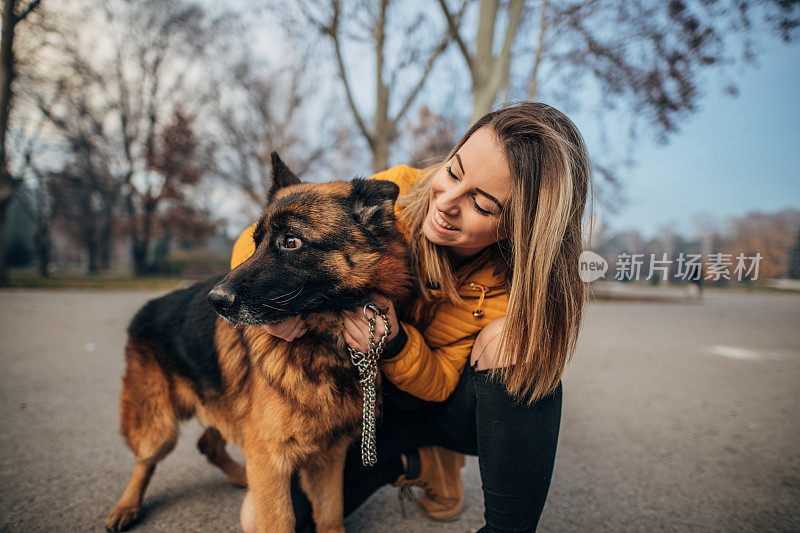 公园里有个年轻女人和一只德国牧羊犬