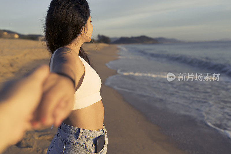 夕阳西下，年轻的一对手牵着手，离开了，向前走去。海滩的弗洛