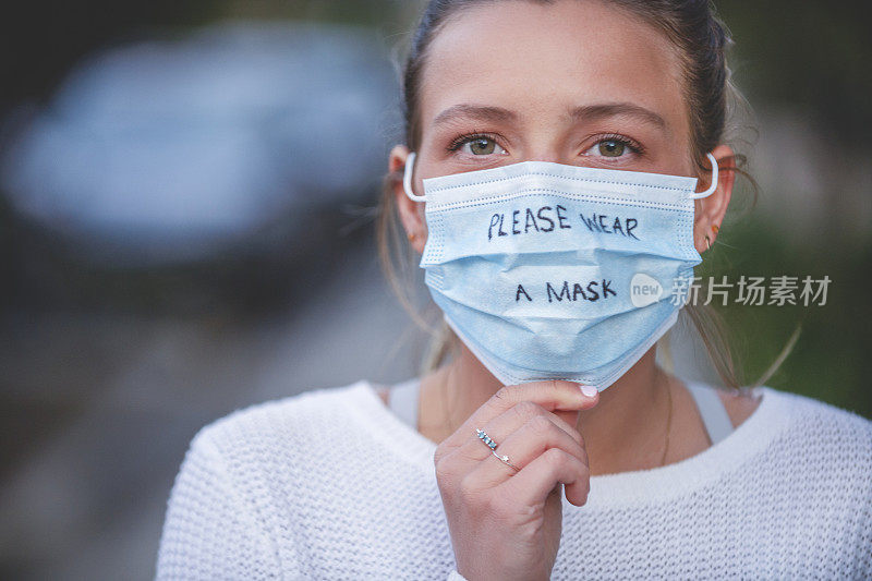 女人戴着医用口罩，上面写着“请戴口罩”