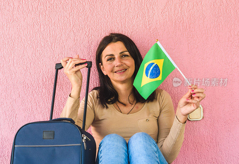 拿着旅行袋和巴西国旗的女人