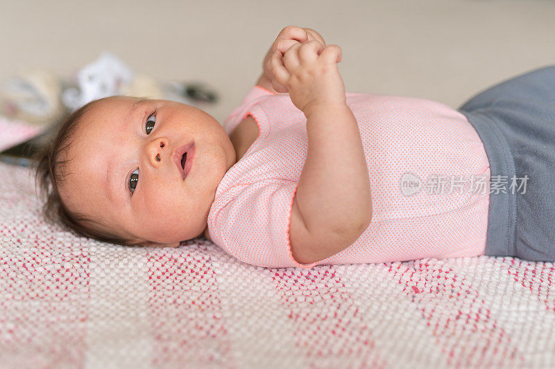 三个月大的婴儿躺在毯子上