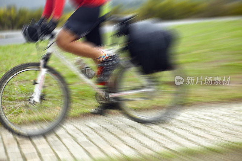 年轻人，骑自行车骑得快，动作模糊。