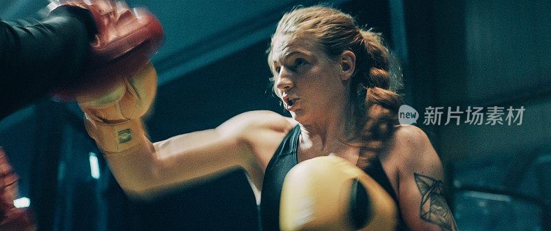 女性拳击手垫训练课程与教练。快速打八角形