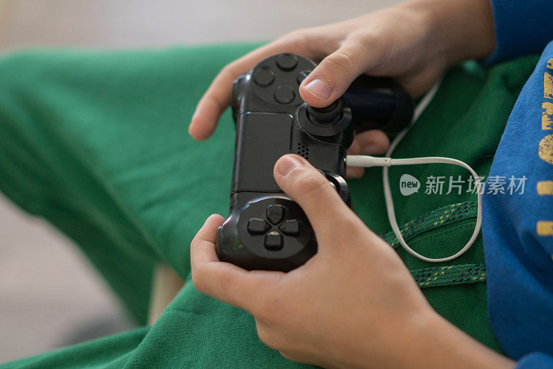 近距离青少年男孩的手沉迷于视频游戏。