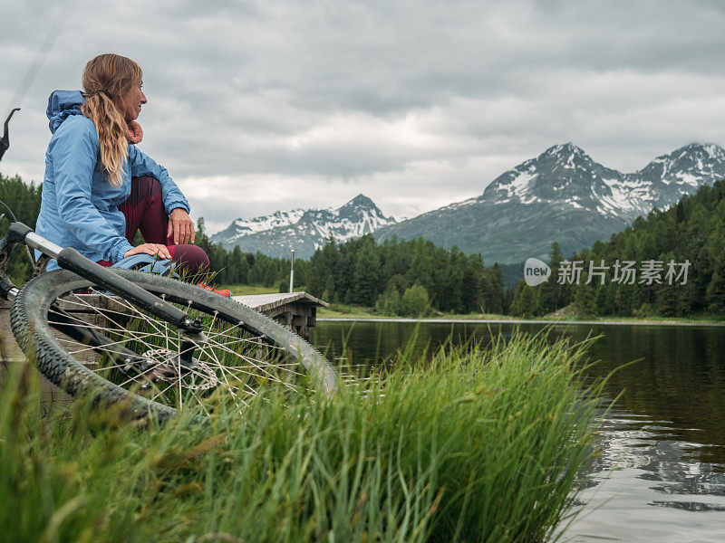 骑山地车的人在湖边看美丽的山景