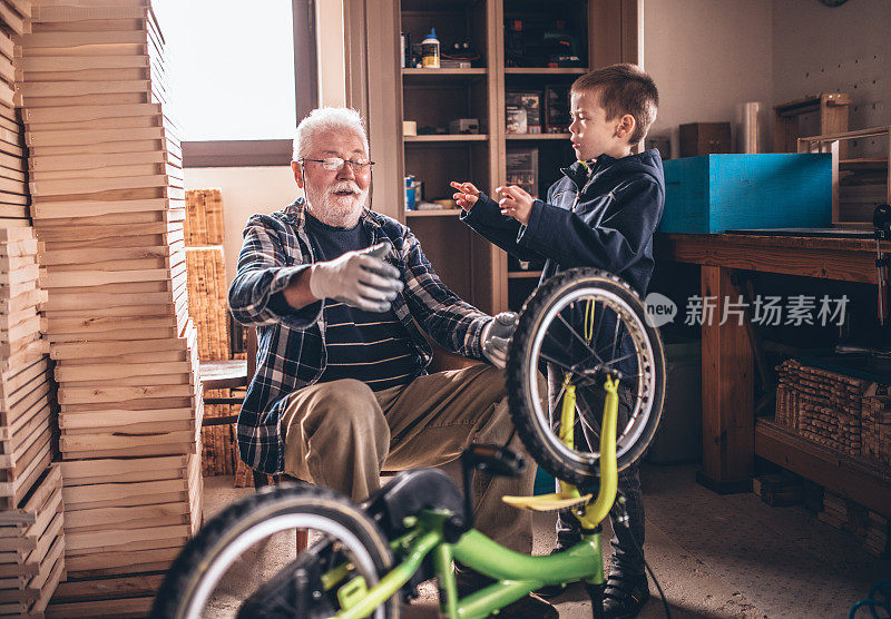 爷爷和孙子们在车间里修理一辆自行车