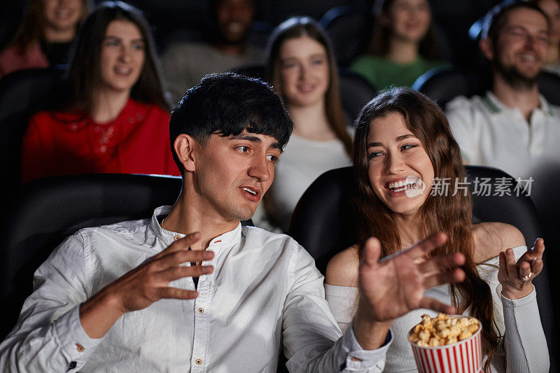一对白人夫妇在电影院讨论电影。