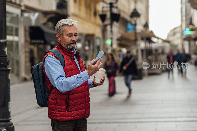 老男人喝着咖啡，在街上打电话