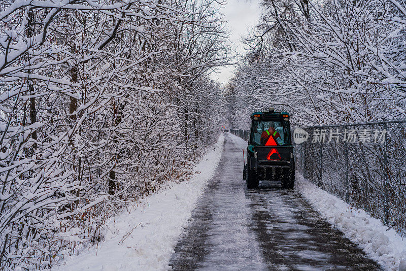 汉密尔顿，安大略-拖拉机清除雪地沿着人行道