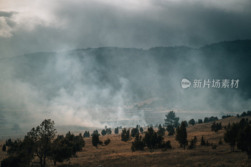 在非城市地区，靠近山区的土地火和烟。波斯尼亚和黑塞哥维那比耶拉斯尼察燃烧的土地上浓烟滚滚