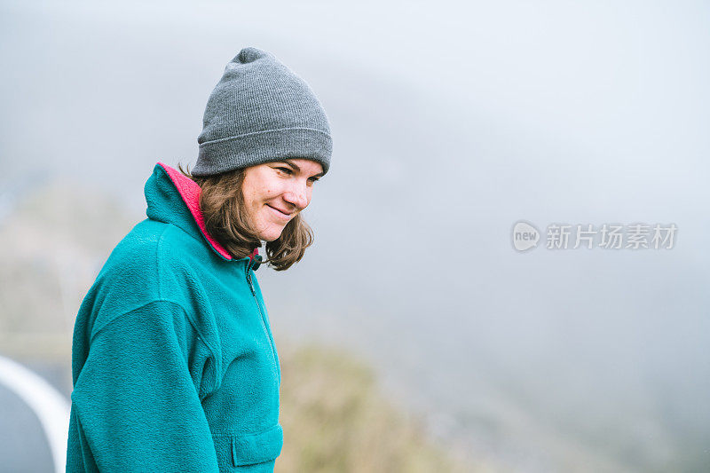 清晨，年轻女子在大雾弥漫的山路上休息