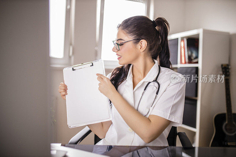 年轻漂亮的女医生有视频通话和显示医疗文件给病人