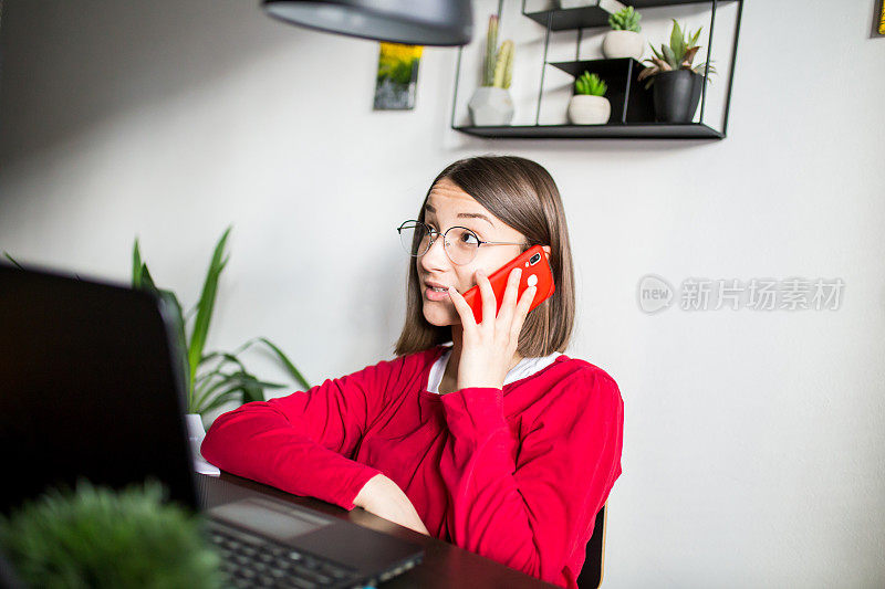 开朗的女孩用手机做作业