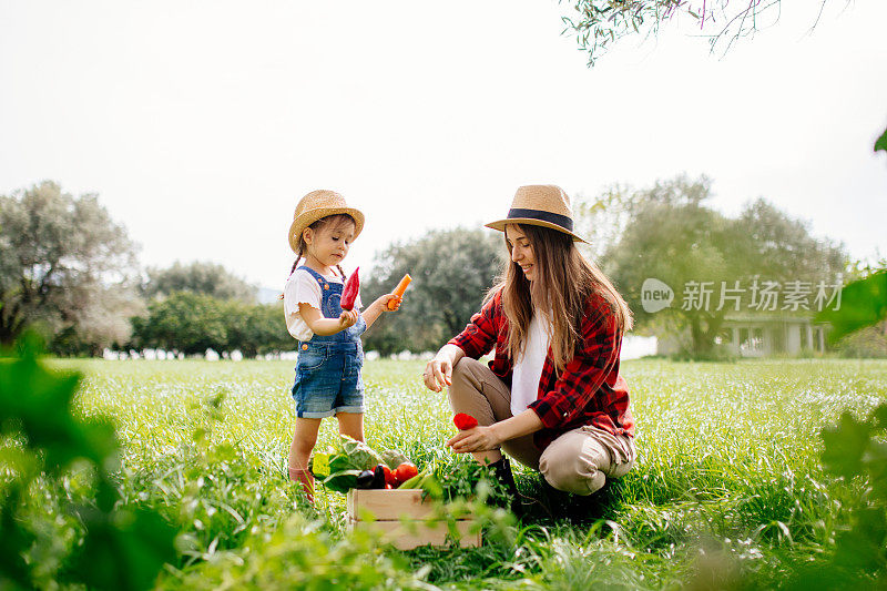 母亲和女儿在农场里吃新鲜蔬菜