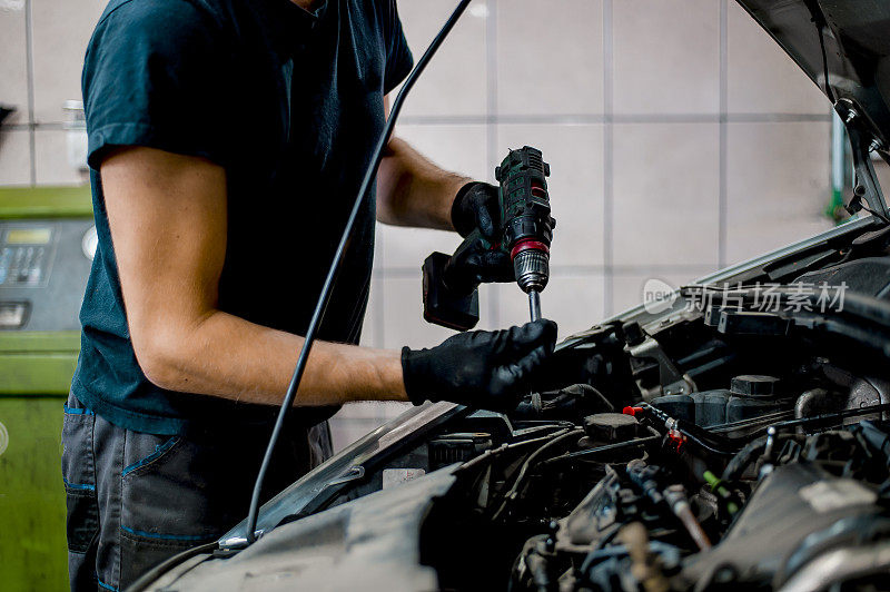 汽车修理工在汽车修理厂修理汽车发动机