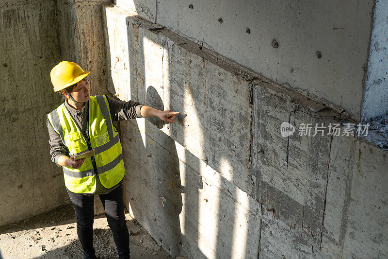 女工程师在施工现场检查混凝土墙