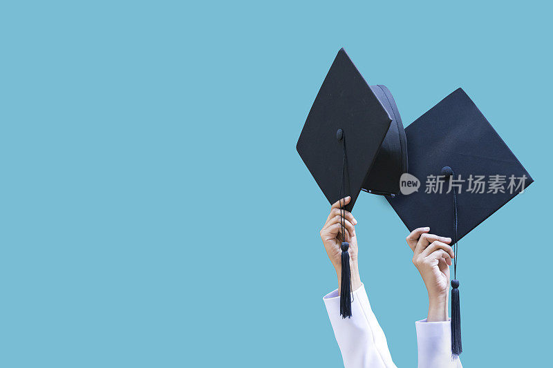 毕业生的毕业帽扔在一个蓝色的孤立