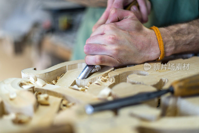 用凿子在木头上工作并进行木雕的木雕匠。