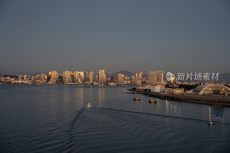 圣地亚哥城市景观从海湾在一个平静的晚上与汽艇和Wake